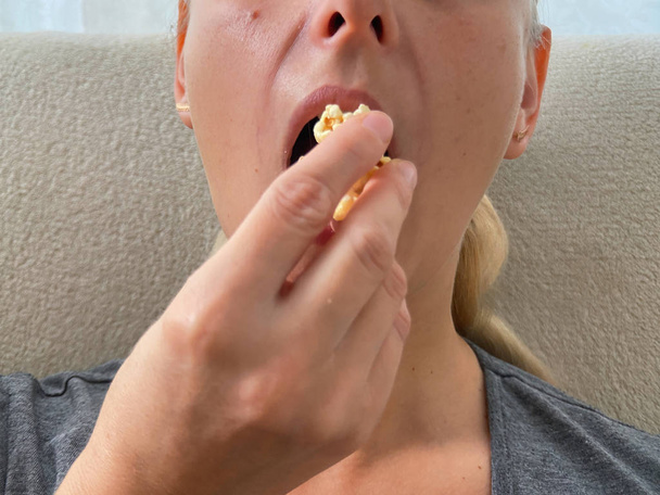 Νεαρή γυναίκα τρώει ποπκόρν από κοντά - Φωτογραφία, εικόνα