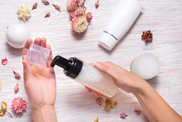 Face foam wash with natural ingredients in woman hands, wooden table - Fotografie, Obrázek