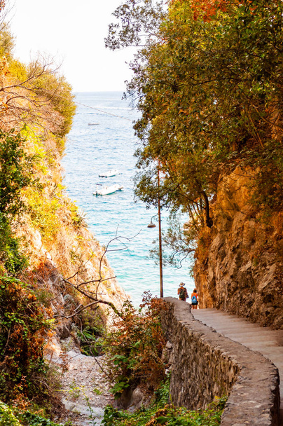 Promenade panoramique au bord de la montagne rocheuse et de la baie de mer tyrrhénienne à Positano. Bateaux flottant près de la côte rocheuse
 - Photo, image