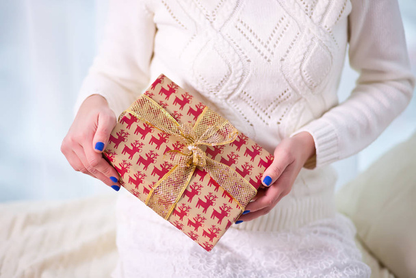 Woman holding a Christmas gift box in a hands on the white background - Fotografie, Obrázek