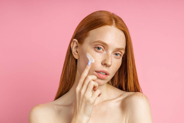 Beautiful young ginger woman with cream on face - Valokuva, kuva