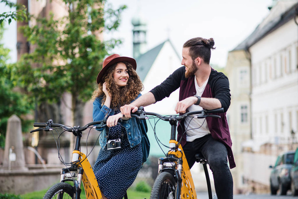Jovens viajantes casal turístico com scooters elétricos em pequena cidade
. - Foto, Imagem
