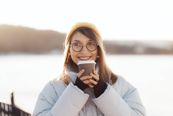 Happy young teenage woman holding a takeaway coffee cup - Фото, зображення