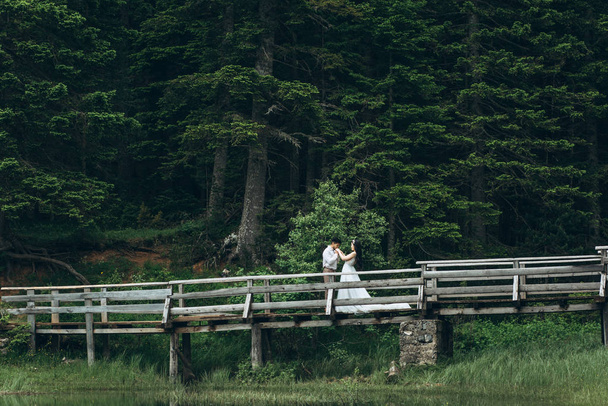 Bräutigam mit Braut auf einer Brücke - Foto, Bild