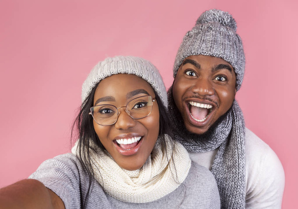 Emotional black winter guy and girl taking selfie together - Photo, Image