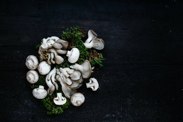 Oyster sienet makaavat tumma puinen pöytä
 - Valokuva, kuva