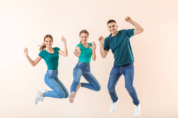 Jongeren tegen een achtergrond van kleuren laten springen - Foto, afbeelding