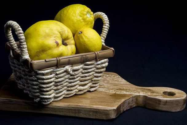 still life with basket and yellow fruits of autumn - Photo, Image