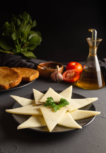 Dilimlenmiş peynir tabağı. rustik koyu arkaplan - Fotoğraf, Görsel