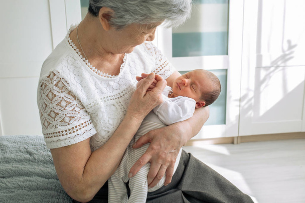 Babička obdivuje svou sladkou vnučku. Prababička si hraje s novorozenou pravnučkou. Dítě leží v náručí babičky. - Fotografie, Obrázek