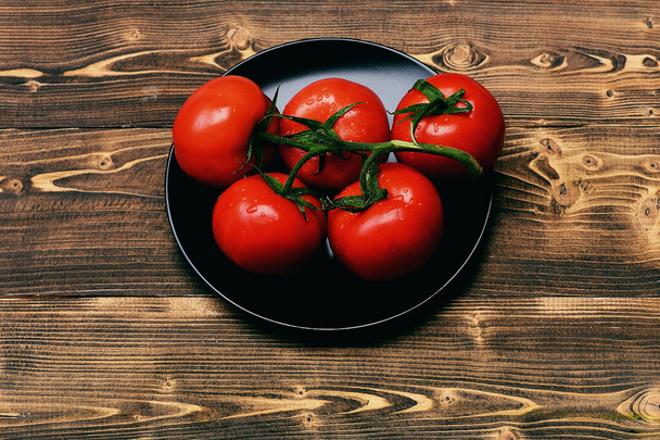 Tomatoes, cherry on vine on on plate, brown vintage background - Foto, Imagem