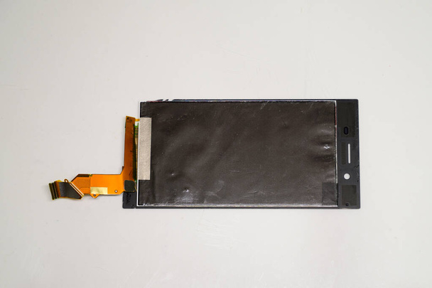 Smartphone repair parts concept. Photo of a broken phone screen on a white background. - 写真・画像