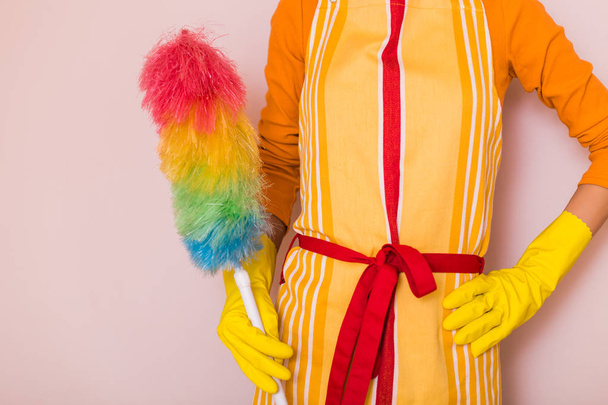 Image of housewife holding duster. - Foto, afbeelding
