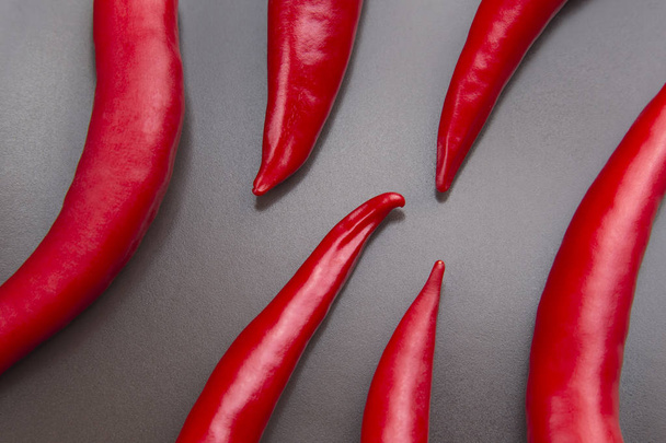 Κόκκινο καυτερό πιπέρι σε γκρί φόντο. Υγιή τρόφιμα και vit - Φωτογραφία, εικόνα