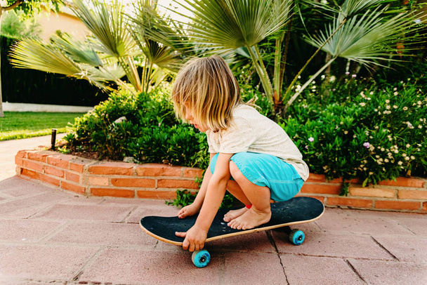 5-jähriger Junge übt Skaten in seinem Hinterhof aus Angst vor Sturz - Foto, Bild