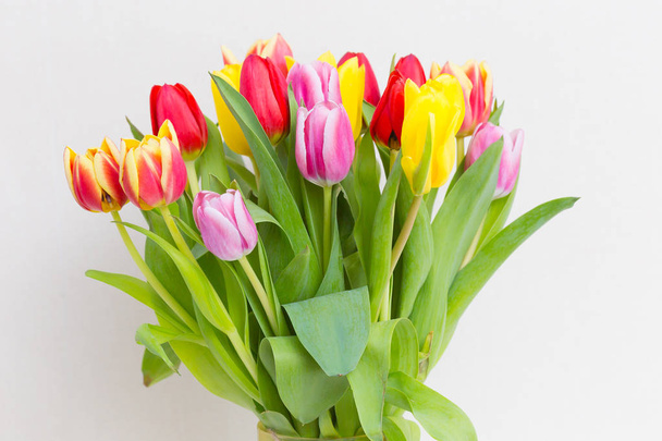 Bouquet of tulips in a vase on a light background - Foto, Bild
