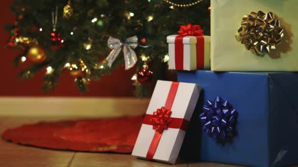 Karácsonyi ajándék dobozok többszínű karácsonyfa fények háttér - Felvétel, videó