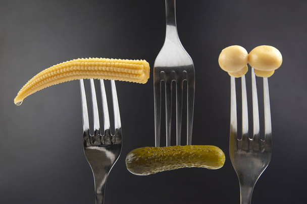 nakládaná okurka, houby a kukuřice na vidličce detailní záběr na dar - Fotografie, Obrázek