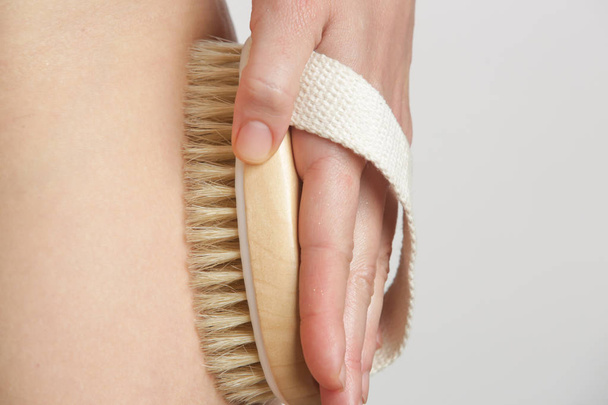 Dry body brush, Woman dry brushing body to reduce cellulite, detoxify the lymphatic system, and achieve beautiful smooth skin. Dry skin brushing as part of morning health and energy routine. - Photo, Image