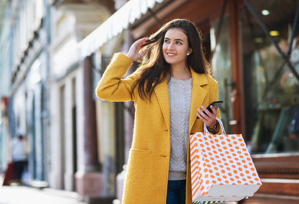 Ritratto di una bella donna con borse da shopping e utilizzando il cellulare
 - Foto, immagini