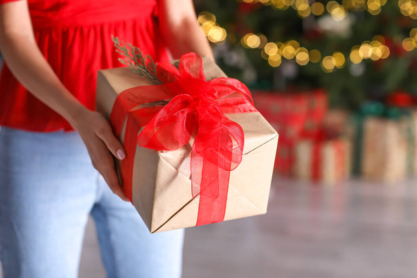 Beautiful young woman with Christmas gift at home, closeup - Photo, Image