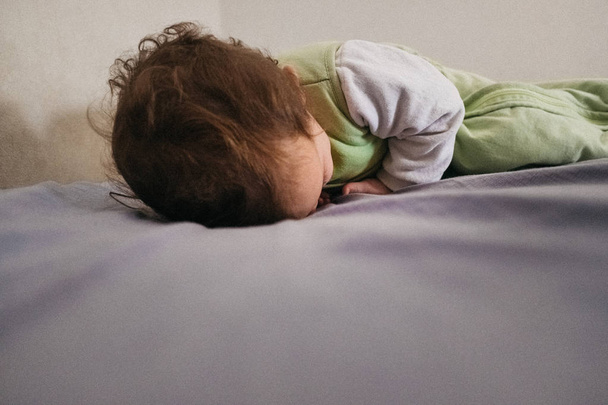 Ребенок спит на кровати в бедной маргинальной семье
. - Фото, изображение