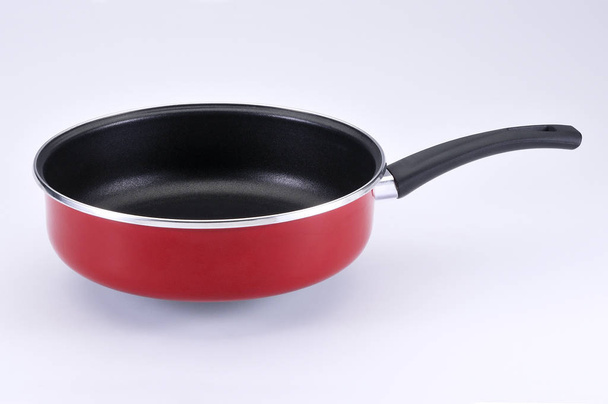 Red tall pan with black handle on white background - 写真・画像