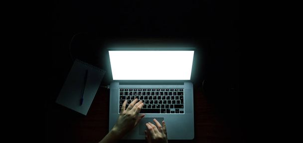 hacker aereo nel cofano che lavora con laptop e telefono cellulare digitando testo in camera oscura
 - Foto, immagini