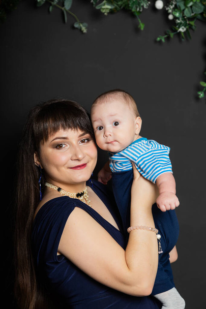 Gyönyörű és boldog anya egy kisfiúval az új évben. Karácsonyi ülés 2020. - Fotó, kép
