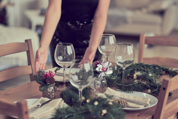 woman is waiting for guests and sets the table. festive laying table, preparation for christmas dinner. - Fotoğraf, Görsel