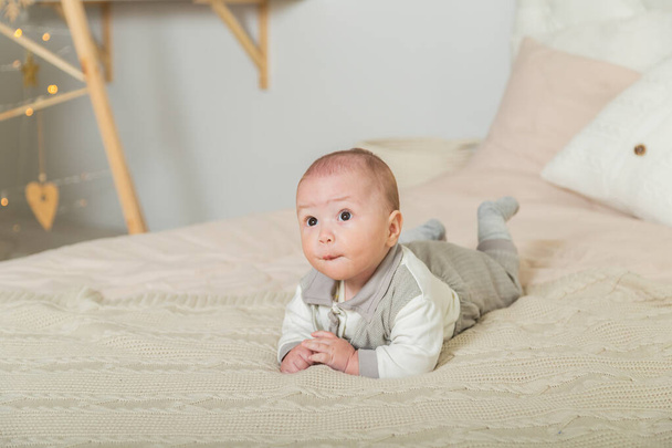 Cute little boy in the New Years room on the bed. - Foto, Imagen