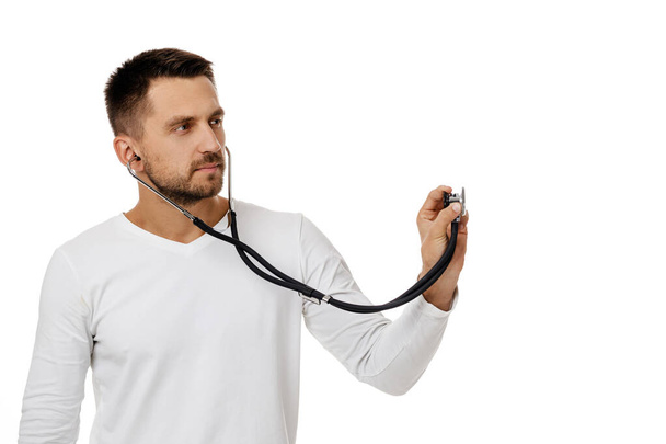 Portrait of an handsome man doctor holding stethoscope - Photo, image