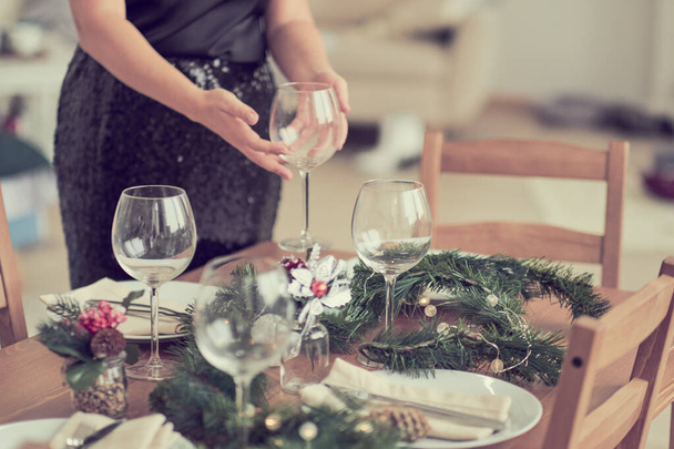 mulher está esperando por convidados e coloca a mesa. mesa de postura festiva, preparação para o jantar de Natal
. - Foto, Imagem