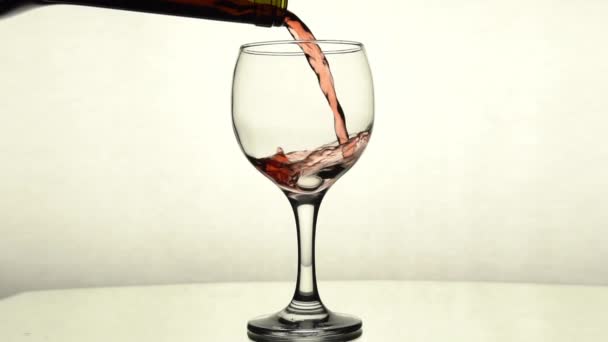 Red wine is poured from a bottle into a glass - Video, Çekim