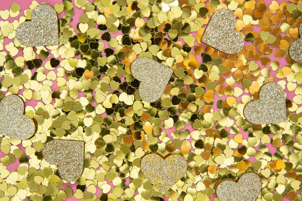 Abstract textured backgraund, golden heart shape glitter over pink background. Valentine's Day, love, birthday, party concept. Flat lay with copy space. - Foto, imagen