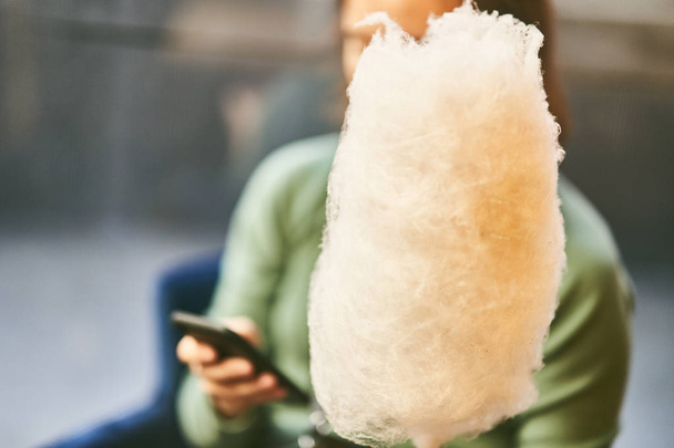 Девушка держит сахарную вату в руке
 - Фото, изображение