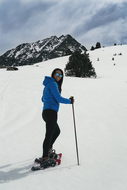 Mladá žena kráčející se sněhem rakety ve vysoké hoře - Fotografie, Obrázek