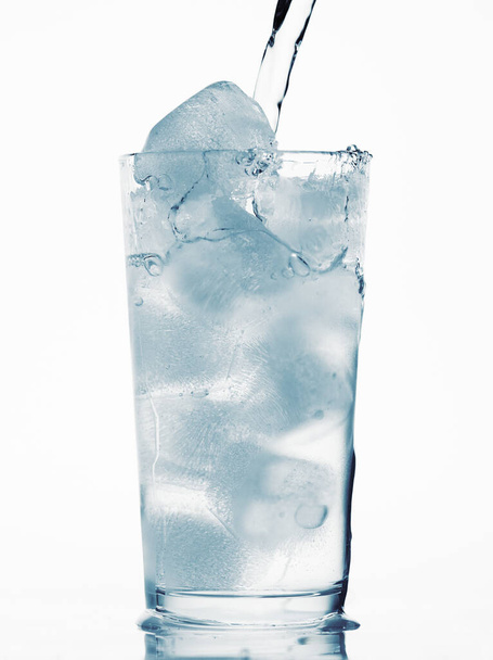 verser de l'eau dans un verre rempli de glaçons, fond blanc, objet bleu
 - Photo, image