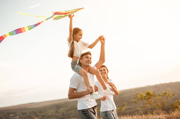 Happy family playing with kite in nature - Zdjęcie, obraz