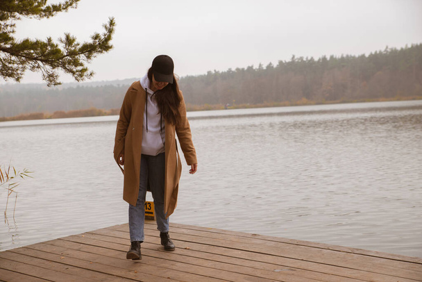 осінній сезон озера жінка в пальто на дерев'яному пірсі
 - Фото, зображення