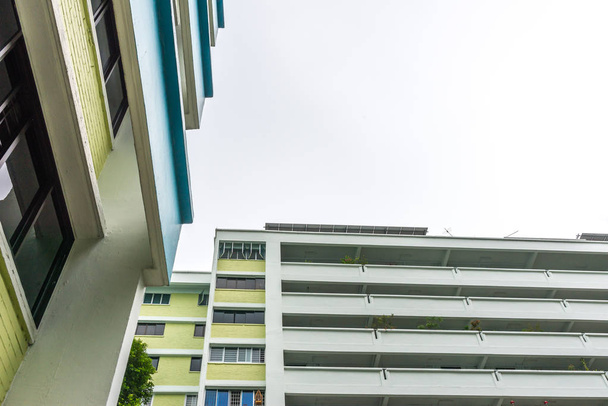 Vista de abajo hacia arriba, en un día nublado, de Public Housing Apartments en Singapur. También conocidos como HDB, estos son apartamentos residenciales verticales construidos por el gobierno
. - Foto, Imagen