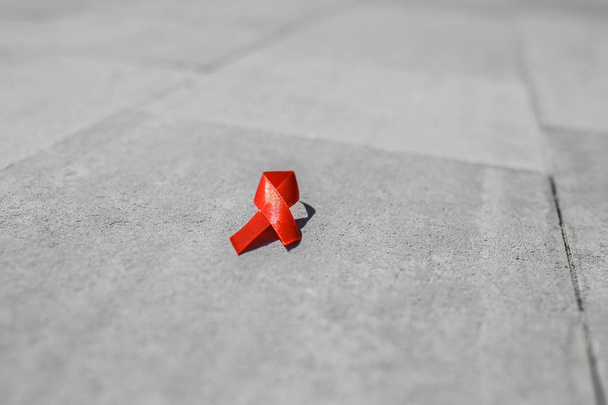 piros szalag szürke kövön, AIDS és HIV szalagon - Fotó, kép