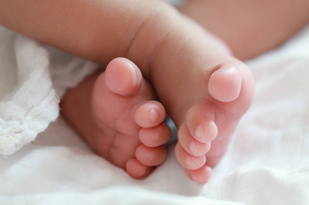 Közelkép mezítláb ázsiai csecsemő újszülött. - Fotó, kép