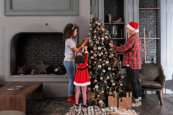 Gelukkig Afro-Amerikaanse familie versieren kerstboom thuis - Foto, afbeelding