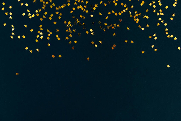 Golden star glitter confetti frame on dark black background. Festive holiday background. Celebration concept. - Foto, Imagem
