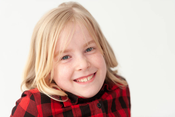 Close up de um sorridente jovem loira pré-adolescente menina em um fundo de estúdio branco
 - Foto, Imagem