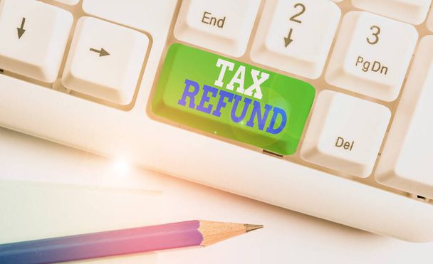Text sign showing Tax Refund. Conceptual photo refund on tax when the tax liability is less than the tax paid White pc keyboard with empty note paper above white background key copy space. - Photo, Image