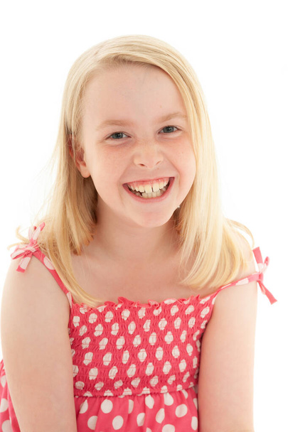 Lähikuva kaunis nuori blondi tyttö iso hymy yllään vaaleanpunainen ja valkoinen pilkku mekko. Eristetty valkoisella studiolla taustalla
 - Valokuva, kuva