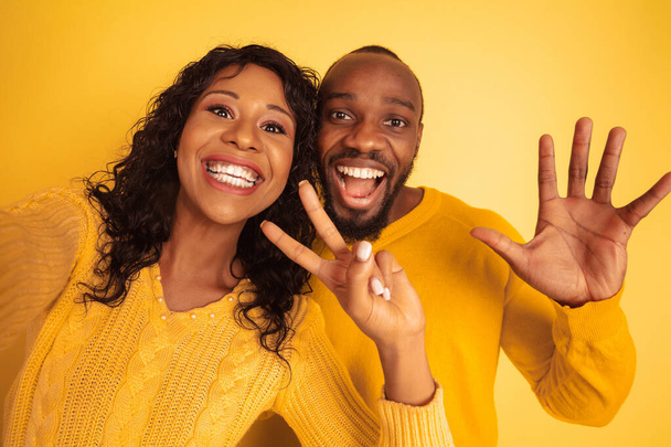 Jovem emocional afro-americano homem e mulher no fundo amarelo
 - Foto, Imagem