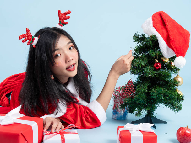 Asian teenager girl wearing Santa Claus costume lying on floor w - Photo, Image